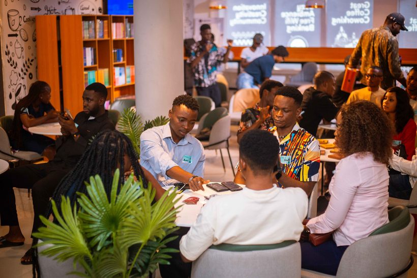 Community members gathered around a table networking and discussing ideas at a co-working space